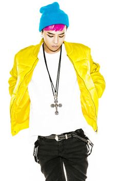 a young man with pink hair wearing a yellow jacket and blue beanie, standing in front of a white background