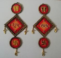 two red and gold earrings with letters on them