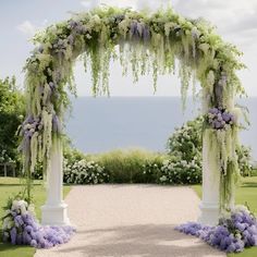 an outdoor wedding ceremony with flowers and greenery on either side of the aisle leading to the ocean