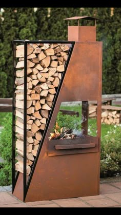 an outdoor fire place with logs stacked on it's sides and a metal chimney