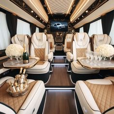 the interior of a luxury vehicle with white flowers and wine glasses on it's trays