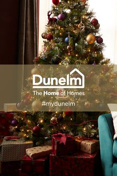 a christmas tree with presents under it and the words dunelom in front of it