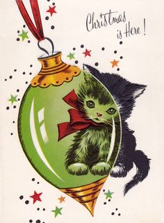 a green christmas ornament with a black cat on it's side and the words, christmas is here