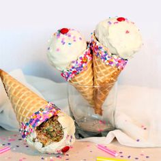 two ice cream cones with sprinkles and confetti in them on a table