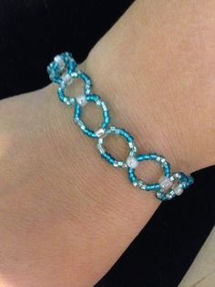 a woman's arm with a bracelet made out of blue beads and glass beads