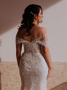 a woman in a wedding dress looking back