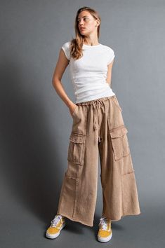 Netflix and Chill Mineral Washed Wide Leg Cargo Pants in Latte The comfiest and trendiest wide-leg pants just hit the scene! Say "Yes" to a wide-leg silhouette with a draw-string waist in soft French Terry. Vintage fade makes these a casual favorite while visible seams, full-length raw-edges, and functional pockets add to the relaxed vibe. Shorter gals look no further, these are an awesome crop style that will make the perfect full-length pants for you! Item Deets: Waist laid flat: (S) 14" (M) 1 Beige Wide Leg Harem Pants For Fall, Beige Wide-leg Harem Pants For Fall, Relaxed Fit Wide Leg Harem Pants With Cargo Pockets, Beige Wide Leg Summer Pants With Cargo Pockets, Summer Beige Wide Leg Pants With Cargo Pockets, Summer Beige Wide Leg Cargo Pants, Baggy Wide Leg Parachute Pants In Beige, Beige Wide Leg Linen Cargo Pants, Wide Leg Linen Cargo Pants For Loungewear