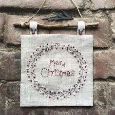 a christmas card hanging on a brick wall with the words merry christmas written in red