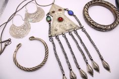 Exactly as pictured, a lot of tribal jewelry. Includes a Miao Hmong twisted cuff bracelet (~60% silver), a pair of possibly Uzbek hoop earrings, an Afghan (Turkmen or Kuchi?) large fringe pendant on matching foxtail chain, and a large hollow bangle bracelet. Each piece shows wear, the earrings have spots of verdi gris that should come off with vinegar. There is a spot on the Miao bracelet and it is not perfectly oval. The chain of the necklace has kinks. These are functional pieces with vintage Tribal charm. The collection is sold "as-is." Unique Silver Jewelry For Festivals, Vintage Silver Jewelry For Festival, Handmade Bangle Jewelry For Festivals, Asian Jewelry, Bangle Bracelet, Vinegar, Cuff Bracelet, Bangle Bracelets, Jewelry Necklace Pendant