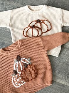 Every babe needs one of these oversized hand embroidered fall sweater! Each one is custom made with desired sweater color, yarn color and selected name or design. These name sweaters would be great for baby announcements, family pictures, first birthdays or as a gift! Each one is truly one of a kind, being hand embroidered unique to your babe. Available in size 3-6 months to 5T. **note, the dark sage blanket is pictured to show the first name and pumpkin design. It is not a sweater. Notes on selected design: --FirstName+PumpkinDot: If the name has a /j/ or /i/ the dot on the letter will be a pumpkin design --FirstName+FlowerDot: If the name has a /j/ or /i/ the dot on the letter will be a sunflower design --Pumpkin ONLY: There will be no name on this sweater, only a full pumpkin design --S Baby Fall Sweater, Handmade Cotton Sweater For Fall, Customizable Cotton Fall Sweater, Customizable Cotton Sweater For Fall, Customizable Crew Neck Sweater For Fall, Cute Custom Embroidered Sweater For Winter, White Sweater With Custom Embroidery For Fall, White Custom Embroidered Sweater For Fall, Sage Blanket