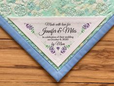 a blue and white wedding handkerchief on top of a wooden table