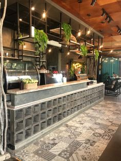 the interior of a restaurant with tables, chairs and an open air kitchen on one side