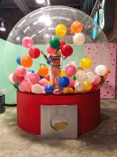 a person standing in front of a snow globe filled with balloons