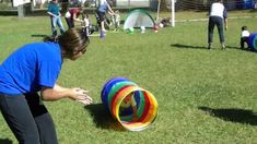 a woman is playing with a colorful ball in the grass