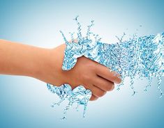 a hand holding water splashing out of it's arm on a blue background