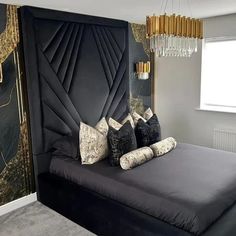 a black and gold bedroom with chandelier hanging from it's headboard