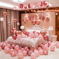 a bedroom decorated with pink balloons and heart - shaped confetti for valentine's day