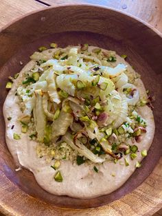 a wooden bowl filled with food on top of a table