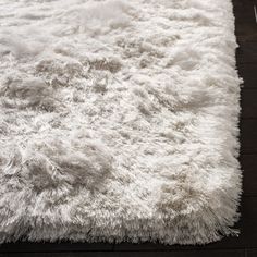 a white rug on top of a wooden floor