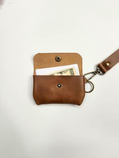 a brown leather wallet with money sticking out of it's front pocket on a white background