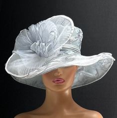 The featured hat is a large black, white and bluish grey print fabric hat. The hat is adorned with a large white crinoline fan disc. In the center of this disc is a bluish grey grouping of large chiffon petals. Lying in the middle of this design are several silver plated metal flowers cut out to be flowers. The hat is so dramatic, classic and romantic, it's a must have for any woman who loves hats! Creating the look that suits you best comes from turning the hat on your head creating a different look with each twist till you find the look you love. This large dramatic hat is  a one of a kind hat made by Letty.  It is a gorgeous  Kentucky Derby Hat.  Also perfect  a Tea Party hat,Wedding Party Hat,Church event hat, Fancy Dress hat, Downton Abby Hat, Audrey Hepburn Hat and other special occa Elegant Gray Summer Hat, Silver Short Brim Hat For Church, Gray Summer Party Hat, Summer Gray Party Hat, Silver Church Hat For Spring, Silver Wide Brim Hat For Kentucky Derby, Gray Curved Brim Hat For Kentucky Derby, Silver Hat For Church In Spring, Gray Short Brim Hat For Kentucky Derby