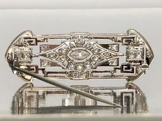 An Antique Elegant and Gorgeous 18K Gold and Platinum Enameled and Diamond Brooch, With a Hallmark of "14601"Total Weight is 7.50 grams. The Center Diamond is Marquise Cut, Measuring 5.75x3mm, and Weighing 0.24ct F/VS2. Surrounded by 24 Single Cut Diamonds, Measuring 1.80 mm – 2mm, Weighing a total of 0.66ctwH/VS2. Art Deco Platinum Brooches In White Gold, Art Deco White Gold Brooch In Platinum, Art Deco White Gold Platinum Brooches, Yellow Gold Art Deco Brooches For Formal Wear, Art Deco Yellow Gold Brooches For Formal Occasions, Art Deco Yellow Gold Formal Brooches, Formal Art Deco Yellow Gold Brooches, Antique Silver Platinum Brooches, Art Deco Platinum Brooches As Gift