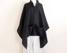 "free size heavy linen swallow poncho coat with big pockets / black linen poncho / plus size linen poncho / linen cape / linen coat / poncho This is a made to order listing. Please mention heavy linen color you prefer when check out. Thank you! heavy linen nice weight great for cool weather long and wide poncho with 2 pockets in the front. super roomy and comfy elegant chipao collar so versatile that you can slide the poncho in different angles yet it still looks great! length 29\" free size tha Black Long Sleeve Cotton Poncho, Oversized Black Summer Poncho, Black Linen Outerwear For Fall, Black Linen Winter Outerwear, Oversized Black Cape For Spring, Black Oversized Cape For Spring, Oversized Lagenlook Poncho For Spring, Black Linen Relaxed Fit Outerwear, Black Oversized Bohemian Cape