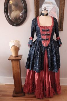 a woman's dress sitting on top of a wooden table next to a mannequin