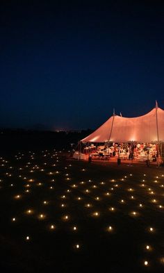 a large tent is lit up at night