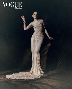 a woman in a white dress is posing for a magazine cover with her hands out