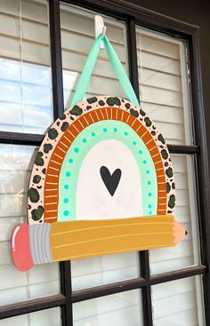 a colorful sign hanging from the side of a window with a heart on it's handle