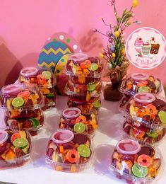 a table topped with lots of candy covered jars filled with candies and toppings