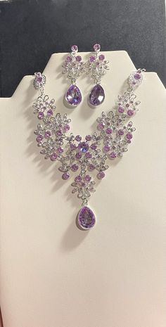 "Purple Crystal Jewelry set , Purple Crystal Rhinestone Necklace & Drop Earrings Set , Silver , Purple Bridal jewelry set Beautiful Necklace is 19 3/4 \" Long + 4 1/4 \" ext. Matching Earrings are 2 \" Long. Round Crystals throughout the necklace and finished with a Teardrop Crystal. Please ask question as I do not accept returns! Thank You!" Purple Assessories Aesthetic, Purple Crystal Earrings, Purple Gem Jewelry, Purple Jwellary, Silver Jewelry Set Wedding, Purple Necklace Crystal, Purple Jewellery Set, Purple Diamond Necklace, Crystal Jewelry Ideas