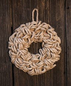 a rope wreath hanging on the side of a wooden door