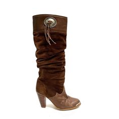 Vintage 1980s Women’s Brown Suede High Heel Knee High Western Slouch Boots By Zodiac. Features Brown Suede Uppers, Brown Leather Foot Box And Top Of Shaft, Rounded Toe With Silver Tone Logo Engraved Toe Plate, Knee High Rise, Slouchy Shaft, Western Style Silver Medallion With Suede Tassels At Top Of Shaft, Logo Fabric Lining, Flat Tops, Pull On Style, And Slanted Wooden Cone Heel. Excellent Vintage Condition. Made In The Usa. Heel To Toe (Inside Shoe): 9.125 Inches Ball Of Foot (Bottom Of Sole): 3.25 Inches Heel Height: 3.5 Inches Shaft Height: 15 Inches Circumference: 14 Inches Size 6.5 Brown Slouchy Boots, 70s Boots, 90s Y2k Fashion, 1980s Women, Slouch Boots, Inside Shoes, Slouchy Boots, Suede High Heels, Suede Tassel