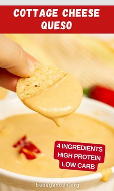 a hand holding a cracker over a bowl of cheese queso