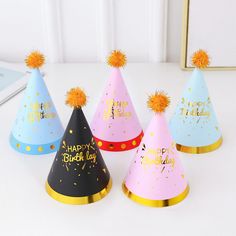 five party hats that say happy birthday and have pom - poms on them