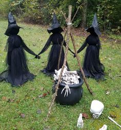 three witches in black costumes standing next to a tree