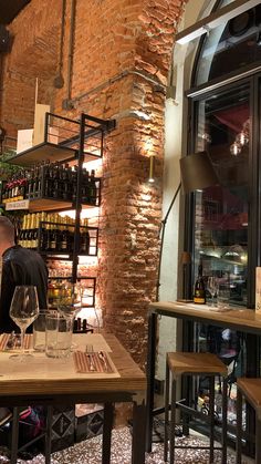 a man sitting at a table in front of a wine rack