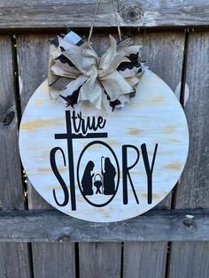 a wooden sign that says true story hanging on the side of a fence with a bow