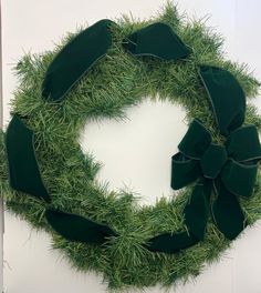 a wreath made out of green grass with bows