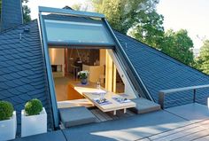 an outdoor living area with couches and tables in front of the house's roof