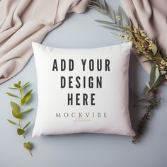 a white pillow with the words add your design here on it next to some flowers