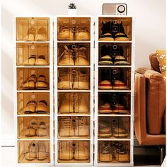 a white cabinet filled with lots of pairs of shoes next to a brown chair and ottoman