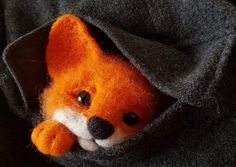 an orange stuffed animal peeks out from its pocket