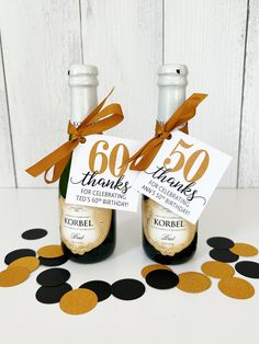 two bottles of champagne with gold confetti on the top and black circles around them