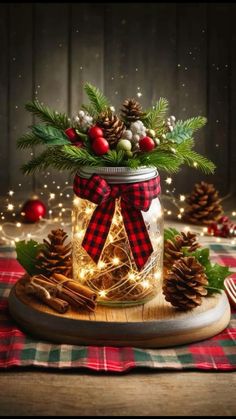 a mason jar filled with pine cones and lights on top of a plaid table cloth