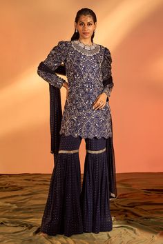 Navy blue kurta with floral hand embroidery. Comes with sharara and a dupatta.
Components: 3
Pattern: Hand embroidered
Type Of Work: Floral
Neckline: Round
Sleeve Type: Full
Fabric: Silk, Georgette, Lining : Shantoon
Color: Blue
Other Details: 
Side slits on kurta
Occasion: Mehendi and Haldi, Sangeet - Aza Fashions Festive Blue Sharara With Intricate Embroidery, Blue Fitted Sharara With Intricate Embroidery, Fitted Blue Palazzo Set With Intricate Embroidery, Blue Fitted Palazzo Set With Intricate Embroidery, Blue Anarkali Embroidered Sharara, Designer Blue Intricately Embroidered Sharara, Blue Embroidered Sharara For Reception, Fitted Blue Sharara With Resham Embroidery, Blue Fitted Sharara With Resham Embroidery