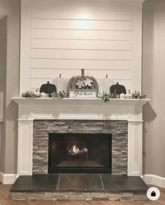 the fireplace is decorated with white pumpkins and greenery on it's mantle