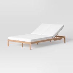 the bed frame is made out of wood and white fabric